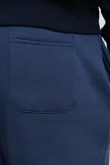 Pantalón jogging de corte recto, confeccionado en tejido circular con cintura elástica y cordón ajustable al tono. Presenta bolsillos laterales tipo parche.