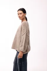 Sweater de punto de textura liviana con escote amplio y mangas largas levemente abullonadas. Presenta un calce relajado y holgado.