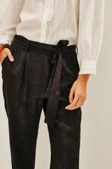 Pantalón negro de viscosa con estampado jacquard, corte holgado y puños elásticos en los tobillos.