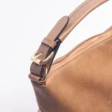 Cartera de hombro color caqui, con diseño de textura granulada y paneles laterales en gamuza. Presenta dos correas decorativas horizontales con hebillas metálicas en el frente, asa superior fija y correa larga ajustable y extraíble.