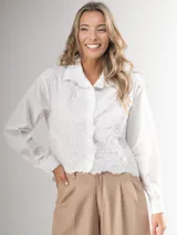 Camisa blanca de manga larga con bordado de encaje en el frente y mangas semi abullonadas.