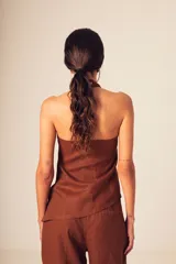 Top de lino color crudo, con cuello halter alto y diseño sin mangas.