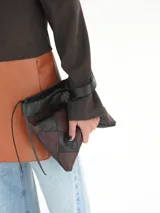 Clutch de cuero con diseño geométrico de rombos en combinación de colores negro y marrón. Presenta una estructura tipo sobre con cierre superior, correa de mano lateral y placa metálica con logo de la marca.