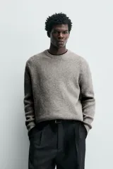 Sweater de punto color beige, de corte relajado, con cuello redondo y diseño texturizado en estructura waffle.