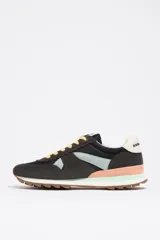 Zapatillas urbanas de la marca Bimba y Lola, confeccionadas en una combinación de serraje vacuno y tejidos técnicos. Presentan un diseño multicolor con base negra y gris, detalles en verde menta y salmón, cordones amarillos y suela dentada de caucho. Incluyen el logotipo de la marca en el estabilizador del talón y la lengüeta.