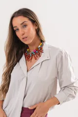 Camisa beige a rayas finas de manga larga, con cuello camisero y cierre frontal oculto.