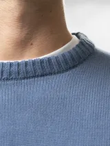 Buzo tejido de cuello redondo, confeccionado en algodón, con puños y ruedo acanalados.