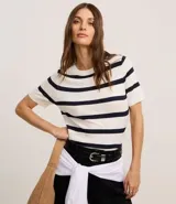 Blusa de punto ligero con diseño de rayas horizontales, cuello redondo y mangas cortas. Confeccionada en una mezcla de viscosa y poliamida, presenta un ajuste al cuerpo.