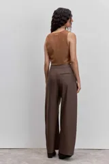Pantalon de vestir de corte wide leg, color marrón con estampado de rayas diplomáticas finas. Presenta cintura alta, bolsillos laterales y cierre frontal.