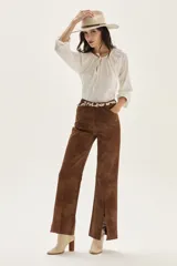 Blusa de algodón de corte holgado, con cuello redondo fruncido y cierre de lazo frontal. Presenta mangas largas con puños elásticos.