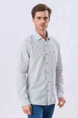 Camisa de manga larga de lino y algodón, con diseño de rayas verticales en tonos celestes y blancos. Presenta cuello camisero, cierre frontal con botones y pequeño bordado al tono en el pecho.