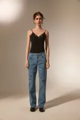 Body de breteles finos color blanco, con escote en V y detalle de encaje en el borde superior. Confeccionado en poliéster, presenta un diseño ajustado al cuerpo con cierre de broches en la parte inferior.