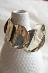 Brazalete rígido plateado con tres discos irregulares de alpaca.