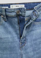 Jeans de tiro alto y corte skinny, confeccionados en tejido de algodón con elástico. Presentan diseño clásico de cinco bolsillos, trabillas para cinturón y cierre frontal con cremallera y botón.