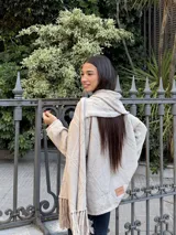 Bufanda tejida con diseño de rombos geométricos y terminación con flecos en los extremos.