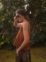 Chaleco de gamuza negro, sin mangas, con cuello redondo y diseño bordado de un sol en el pecho.