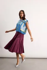 Chaleco de punto tejido a mano con diseño geométrico multicolor en tonos azules, celestes, beige y marrón, sin mangas y con escote redondo.
