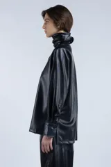 Camisa negra de cuero sintético con cuello clásico con solapas y cierre frontal con botones.