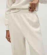 Pantalón wide leg de algodón y poliéster, color beige, con cintura elástica y detalle de costuras verticales frontales.