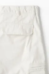 Pantalón cargo de sarga de algodón con corte regular, cintura con cierre de botón, bolsillos laterales, bolsillos insertados en las piernas con cierre y bolsillos de solapa con botones a presión.