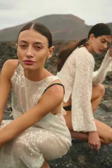 Vestido largo sin mangas, de corte amplio y confeccionado en lentejuelas color plateado.