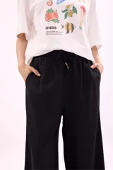 Pantalón palazzo negro de tiro alto con cintura elastizada y cordón ajustable.