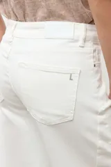 Jean barrel color blanco, de tiro alto y corte relajado con piernas curvas, estilo cropped y presillas en la cintura.