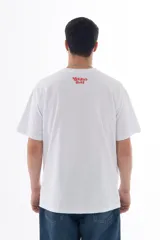 Remera blanca de algodón con estampa frontal de un personaje amarillo en patineta y la frase "Skate and Destroy" en rojo.