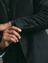 Saco sport de corte clásico, con cuello de solapa, cierre frontal de dos botones y bolsillos de ribete laterales.