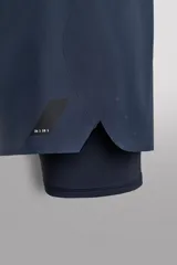 Shorts de entrenamiento azul marino con calza interior negra. Cintura elástica ajustable con cordón, bolsillos laterales con cierre y aberturas laterales en el bajo.