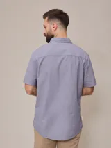 Camisa de manga corta con rayas verticales azules y blancas, confeccionada en algodón.