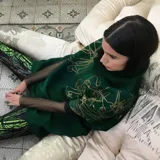 Poncho verde esmeralda de lana merino afieltrada con cuello alto y estampado dorado con diseño abstracto.