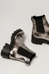 Bota tipo Chelsea de cuero color verde oliva, con paneles laterales elásticos negros y suela track de goma negra con taco cuadrado.