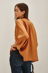 Camisa de viscosa color crema, con cuello mao y cierre frontal de botones. Presenta un delicado bordado floral en el frente y mangas tres cuartos con puños rectos.