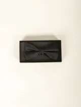 Moño negro liso, pre-atado, con tira ajustable.