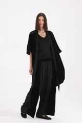 Spolverino largo de terciopelo negro, con mangas tres cuartos y lazo ajustable en la cintura.