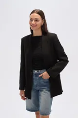 Blazer negro de corte holgado con cuello solapa y bolsillos frontales.