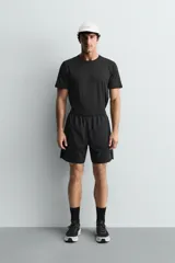 Pantalones deportivos cortos de tejido técnico ligero y elástico, con cintura elástica ajustable, bolsillos frontales y aberturas laterales en el bajo.