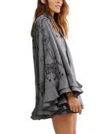 Vestido corto gris con bordados negros, mangas anchas con volados y lazo al cuello.