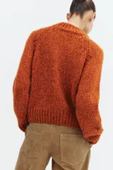 Jersey de punto de cuello redondo y manga larga, con diseño de tejido grueso y acabados en rib en cuello, puños y ruedo.