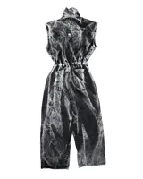 Mono de jean con lavado gris efecto desgastado, con múltiples cortes estructurales, cierre frontal oculto por cartera, cintura elástica y bordado de logo en azul. Incluye un pequeño accesorio de bolso desmontable para la cintura.