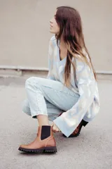 Bota tipo chelsea de cuero color marrón oscuro, con paneles laterales elásticos y suela track robusta con plataforma.