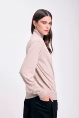 Polera beige de cuello alto y mangas largas.