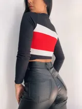 Top manga larga con cierre frontal y diseño tricolor con franjas horizontales en negro, blanco y rojo, fucsia, violeta o azul.