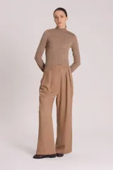 Pantalón sastre de corte amplio y silueta relajada, confeccionado en tejido plano de lyocell. Presenta pinzas frontales, cierre con botón y bolsillos laterales.