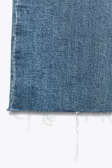 Jeans de tiro alto color marrón oscuro con acabado lavado, corte recto/flare y bajo cropped sin costuras. Presenta cinco bolsillos y cierre frontal con cremallera y botón metálico.