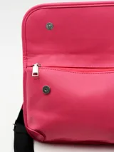 Bolso tipo bandolera de color fucsia, con solapa frontal y correa ajustable de tela negra.