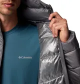 Campera puffer con capucha, color gris, con cierre frontal completo, bolsillos laterales con cremallera y logo de la marca estampado en el pecho. Cuenta con tecnología de reflectividad térmica y aislamiento sintético.