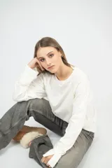 Remera blanca de corte clásico con mangas largas y cuello redondo.