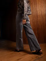 Pantalón de jean corte wide leg, color gris lavado, con tiro alto, cierre frontal con botón y bolsillos laterales.